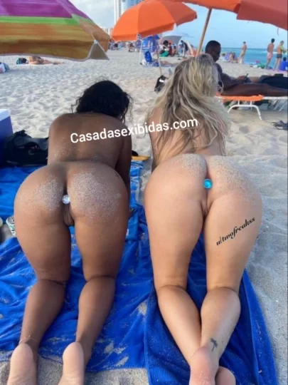Duas mulheres gostosas usando plug anal na praia.